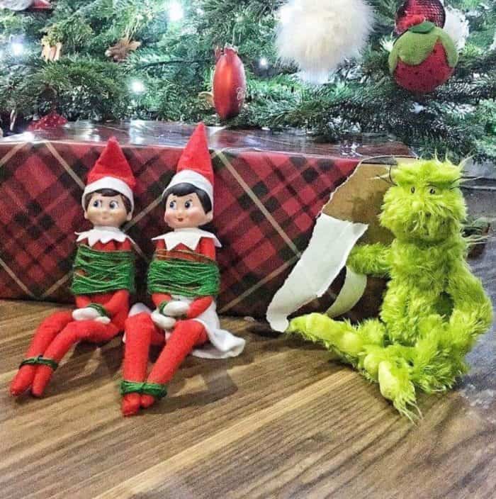 grinch ties elf on the shelf up