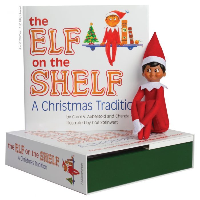 brown elf on the shelf doll siting on elf on the shelf book