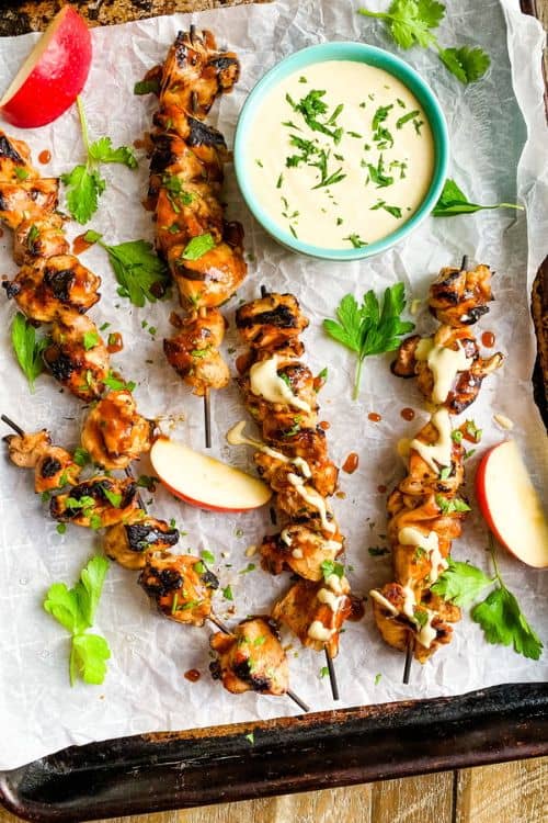 Cider Honey Chicken Skewers on a baking sheet with mustard sauce