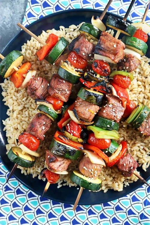 Citrus Marinated Beef Kebabs with bamboo skewers on a black plate