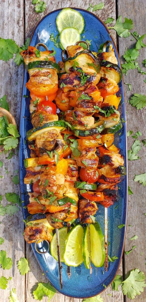 Lime Honey Sriracha Chicken Kebabs on a blue dish with cilantro