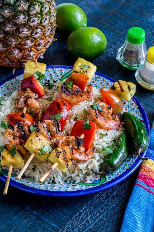 Pineapple Shrimp Skewers over rice on a blue palte