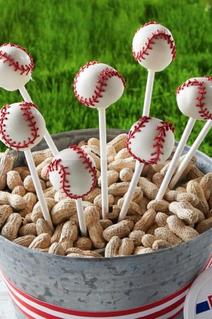 baseball cake pops in a bucket of peanuts
